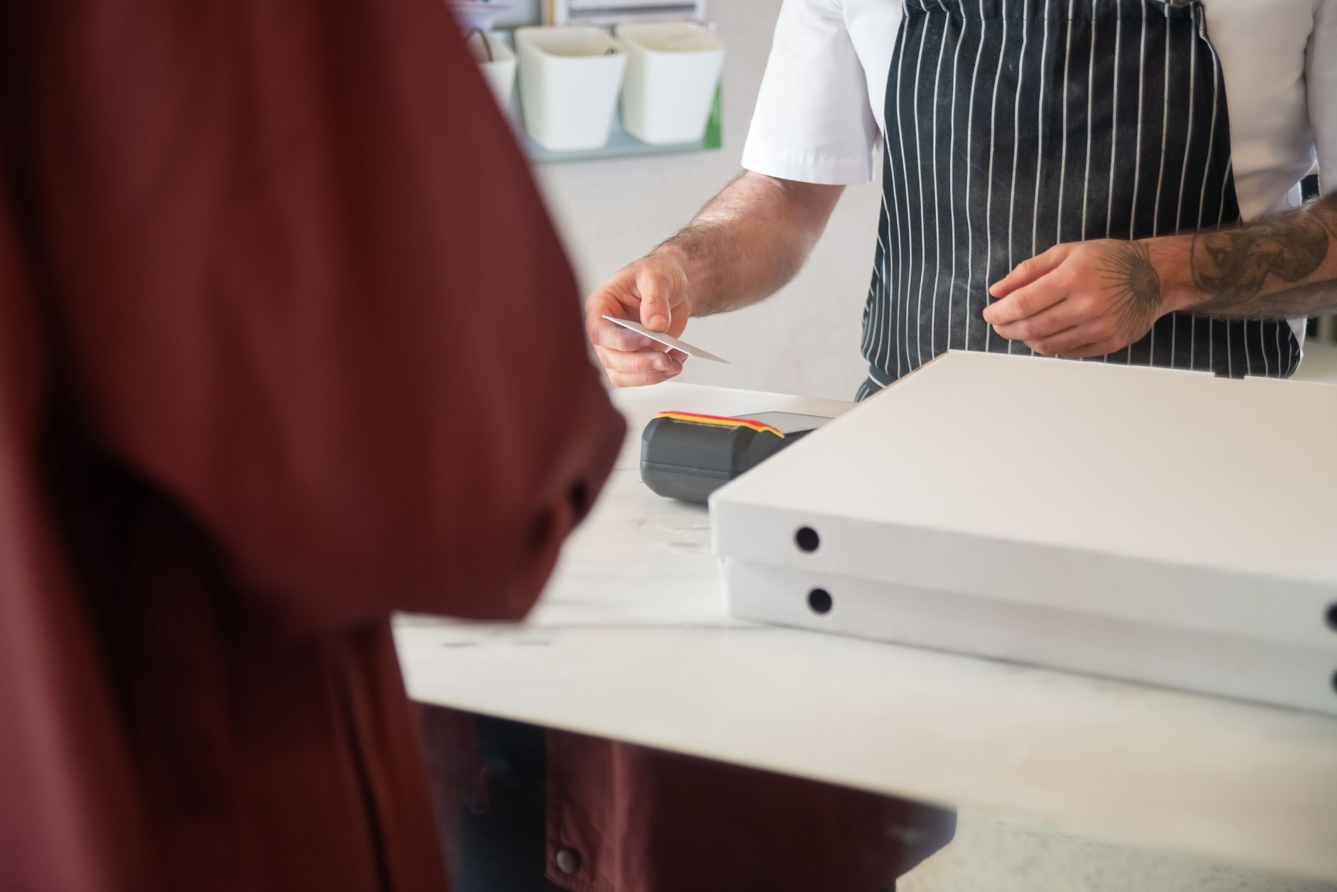 Chef taking a card payment for a pizza order at a counter