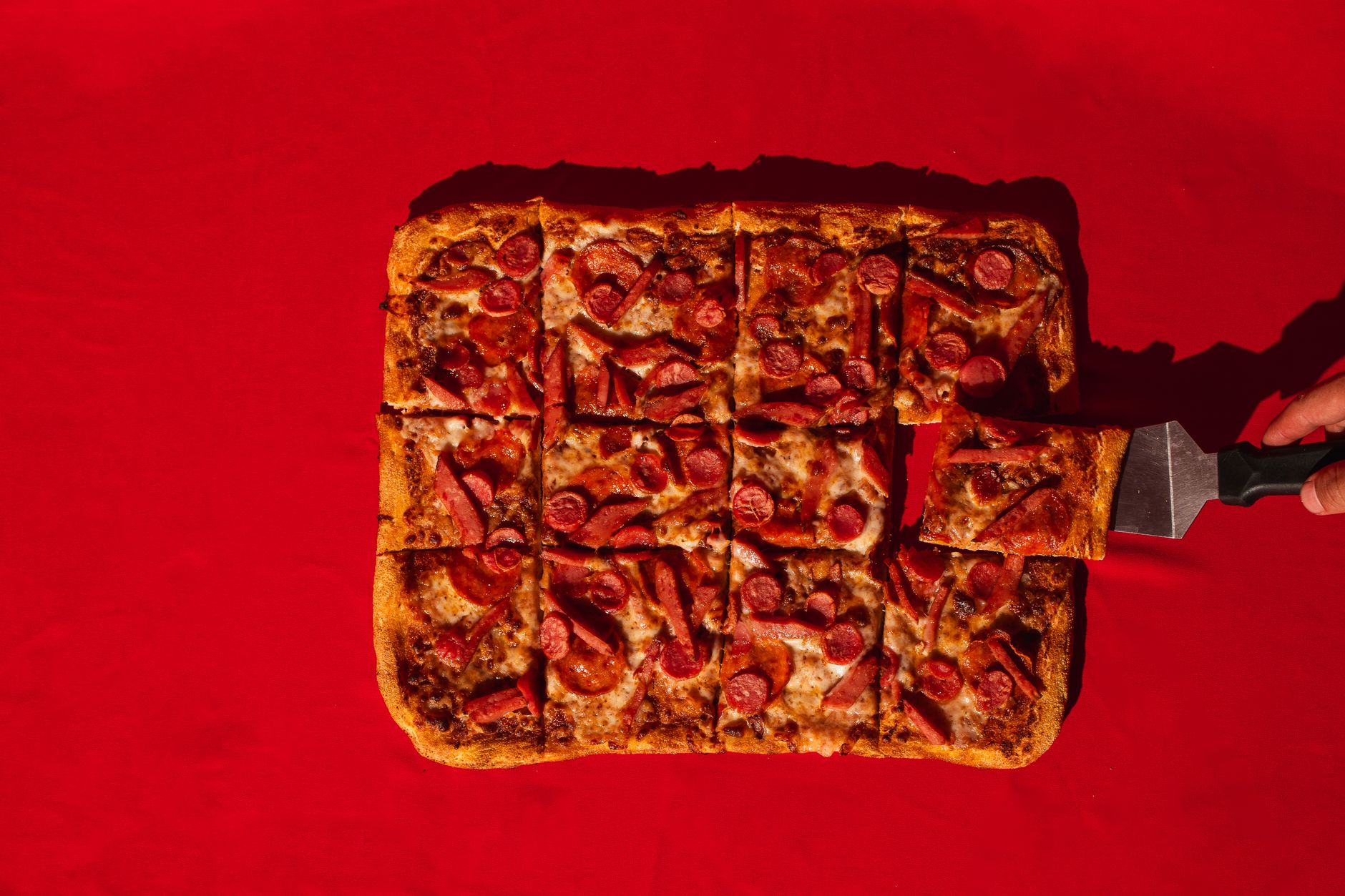Rectangular pan pizza sliced and served on a tray