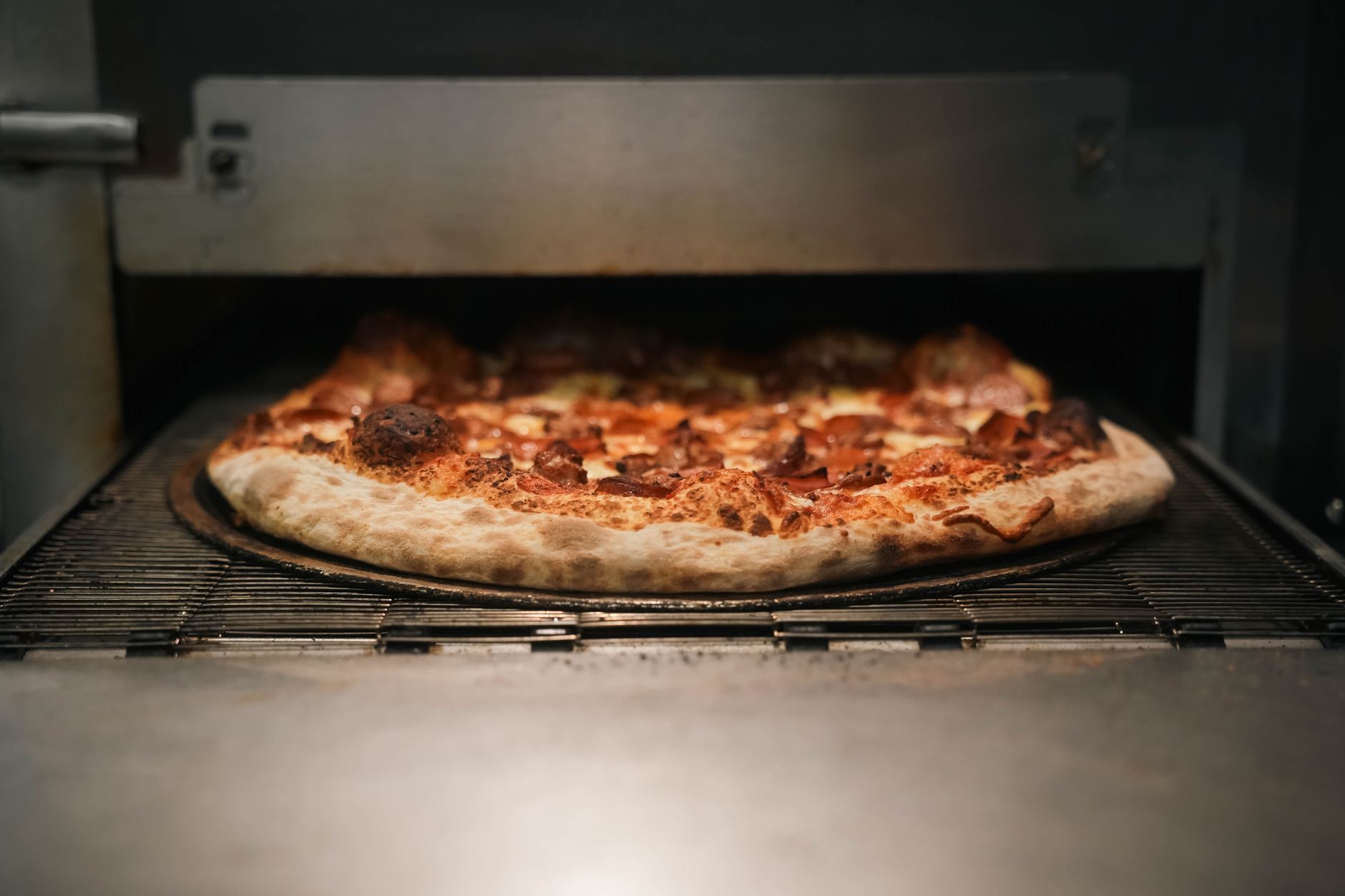 Pepperoni pizza baking in a commercial deck oven