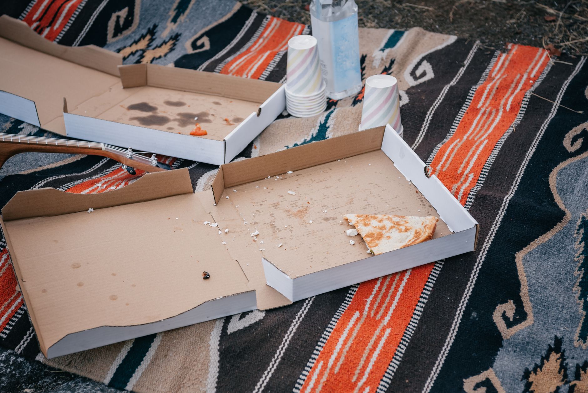 Empty pizza delivery boxes and paper cups after a party