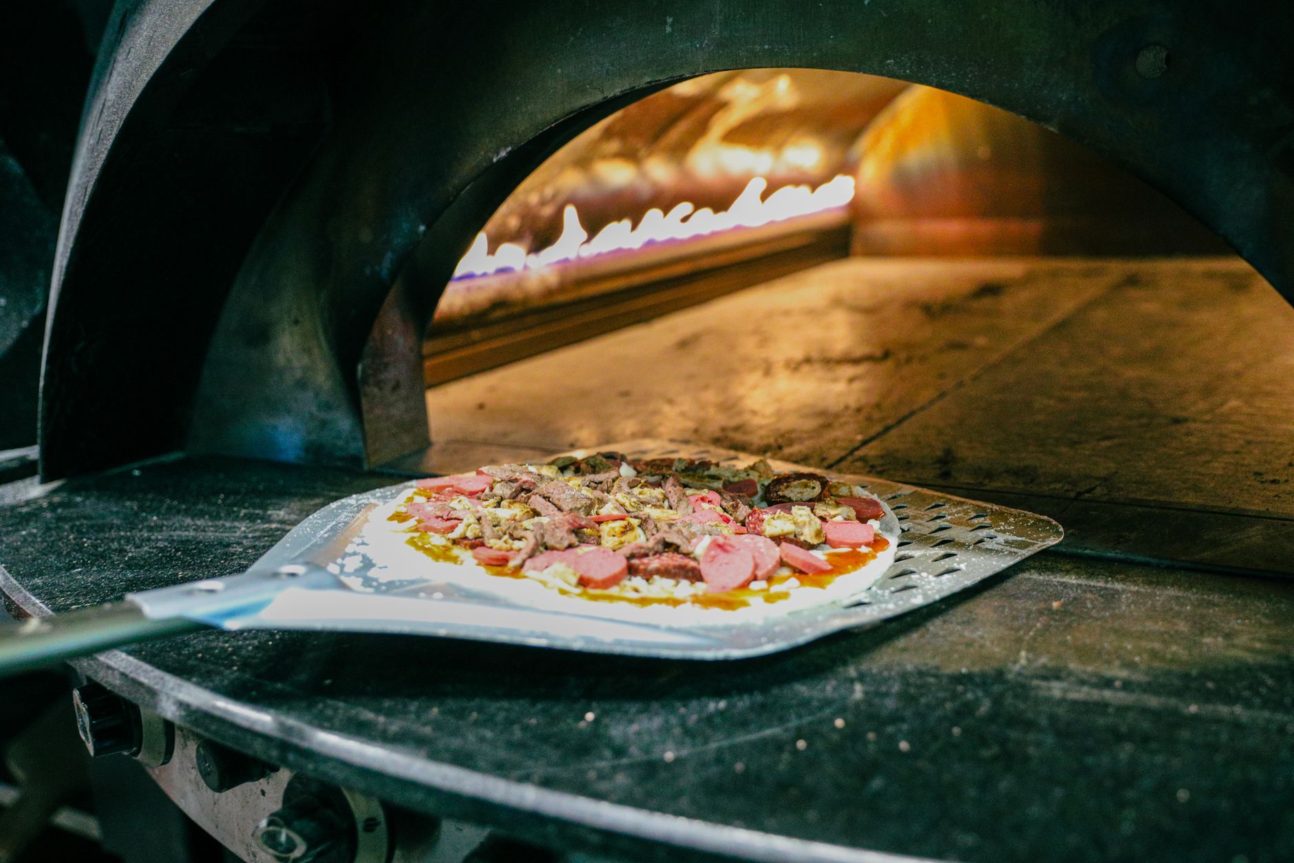 Pizza baking in a traditional wood-fired stone oven