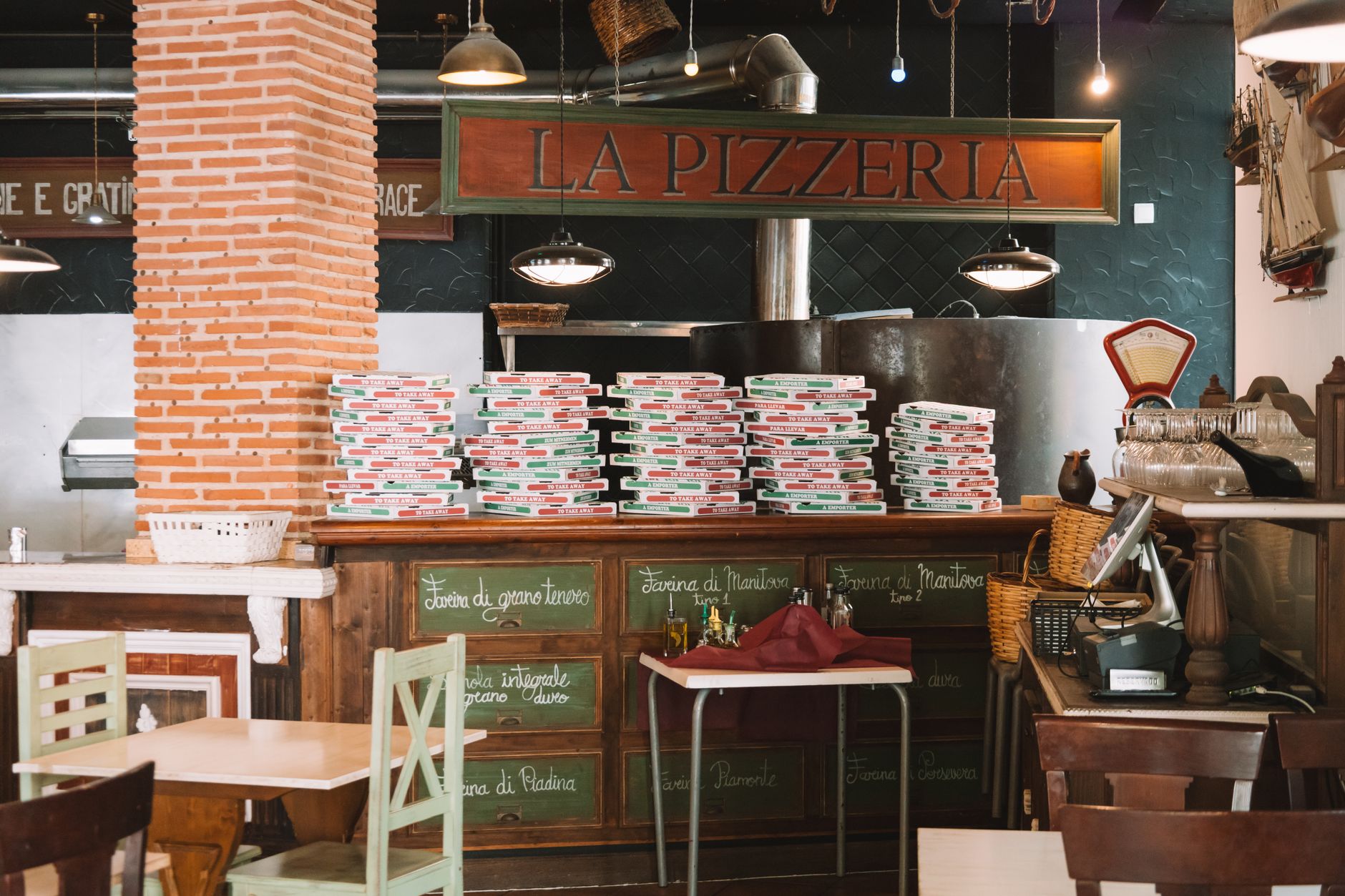 Cozy pizzeria interior with stacked pizza boxes on the counter