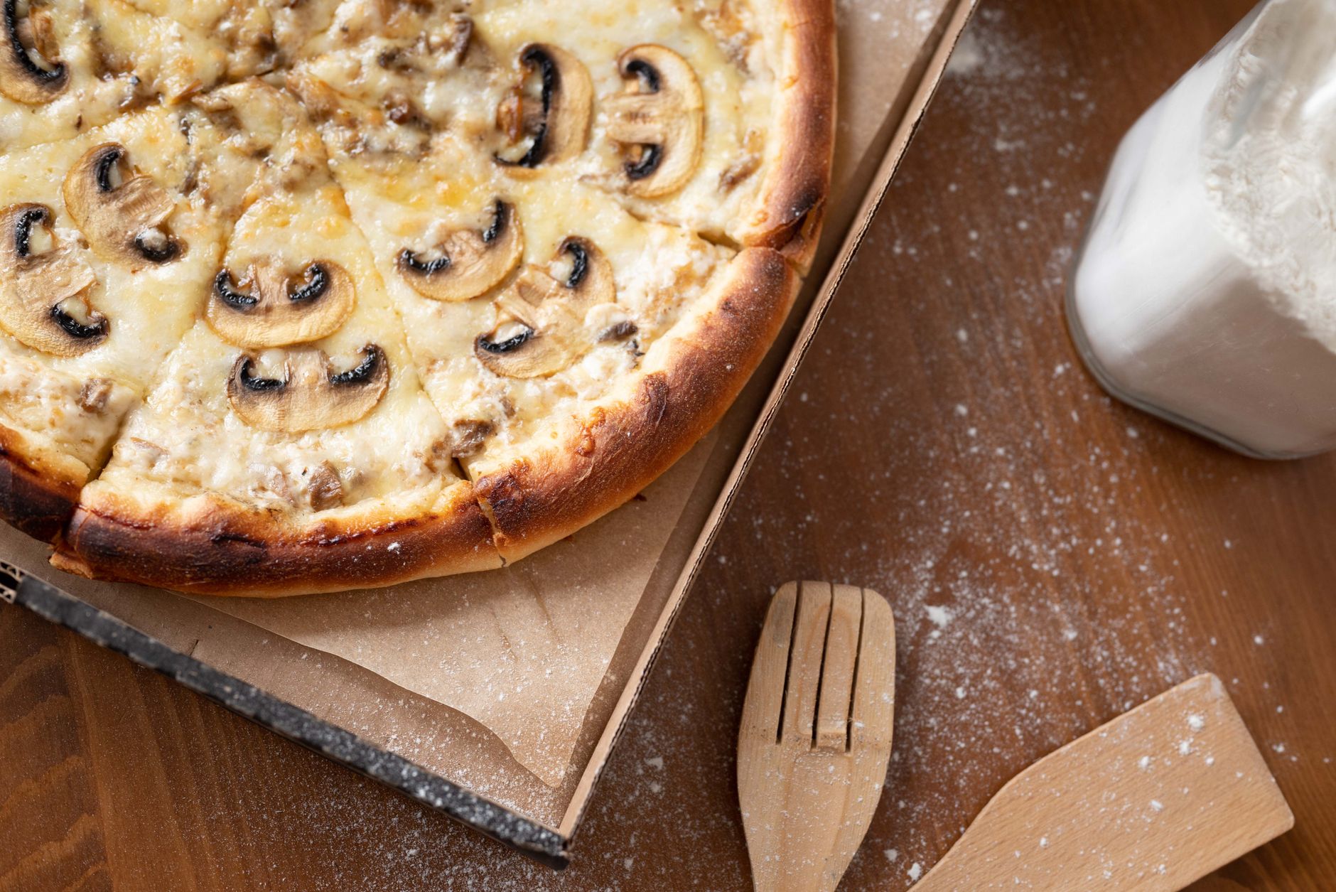 Mushroom and cheese pizza in a cardboard takeout box